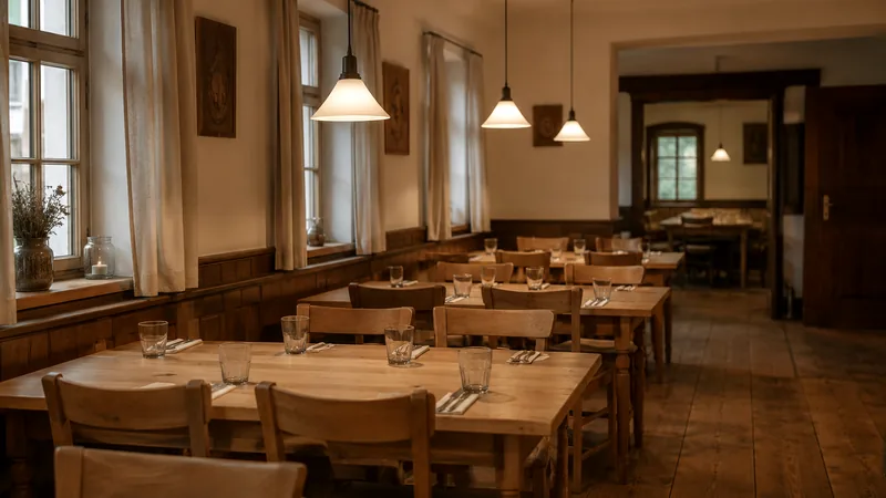Gastraum mit Holztischen und Pendelleuchten am frühen Abend